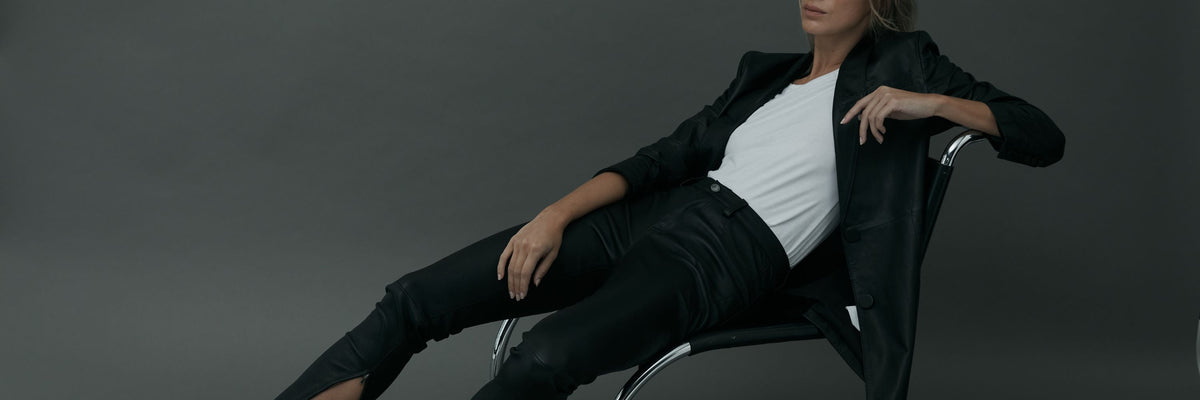 WEST 14TH luxe basics: a leather blazer and leather pants, reclining on a chair